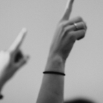 black and white photo of hands raised in the air for generation eqaulity