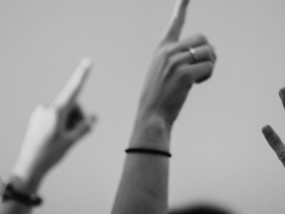 black and white photo of hands raised in the air for generation eqaulity