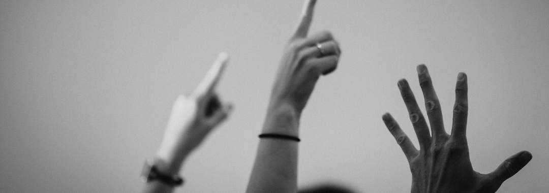 black and white photo of hands raised in the air for generation eqaulity